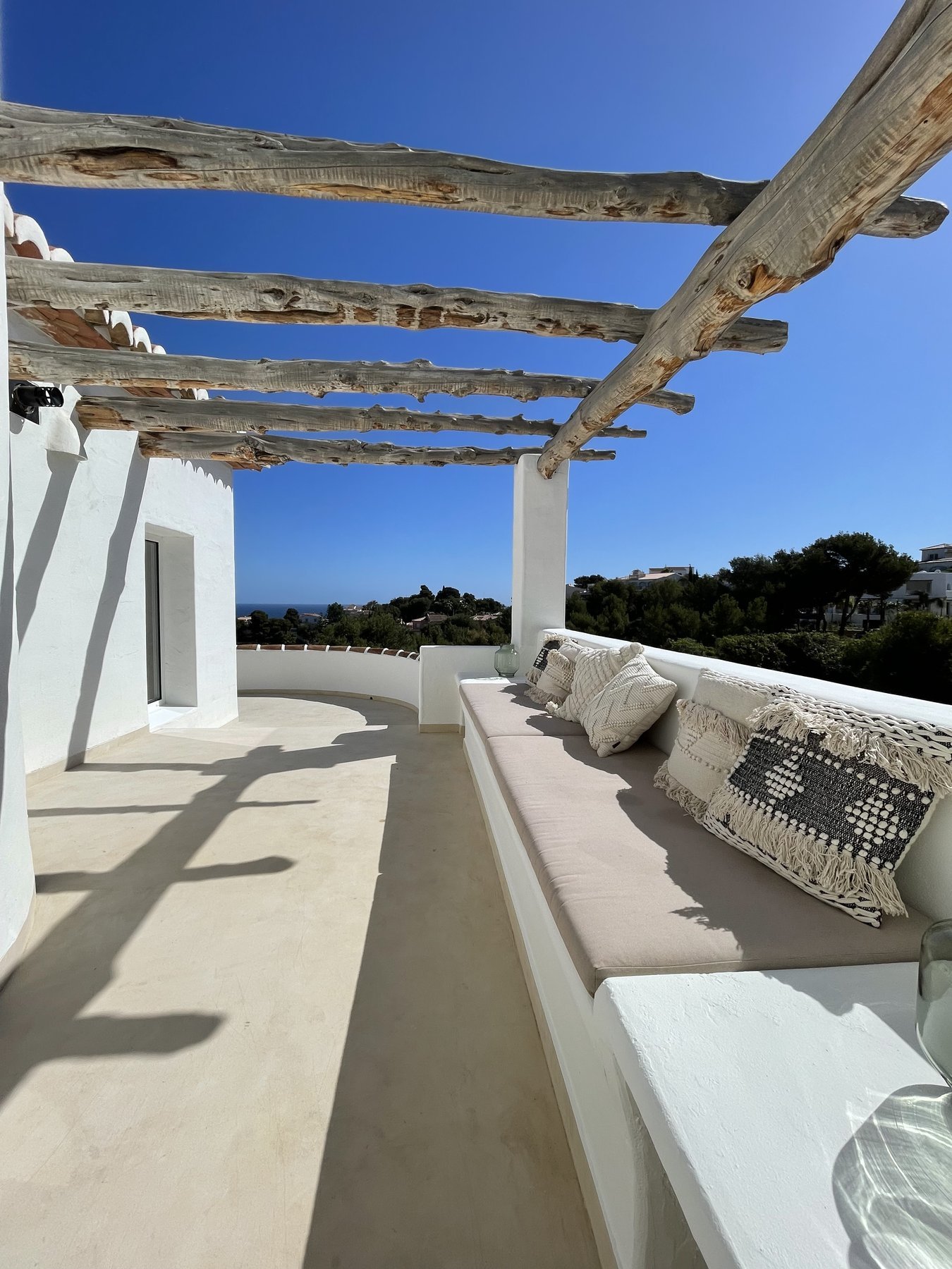 Terraza en microcemento de Casa González con pérgola y vistas al mar en Jávea