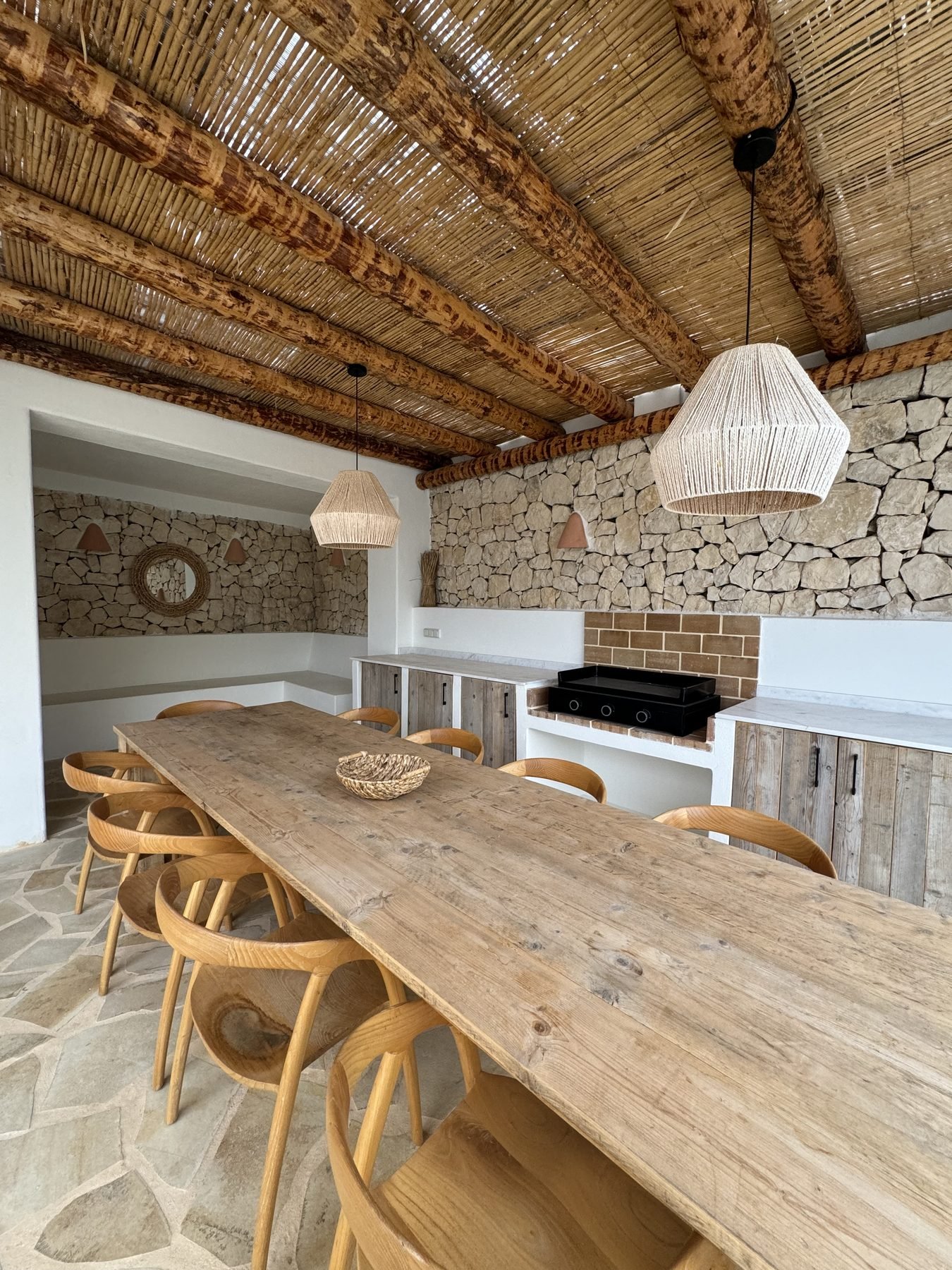 Porche cubierto con techo de cañizo y muro de piedra en villa de Benitatxell