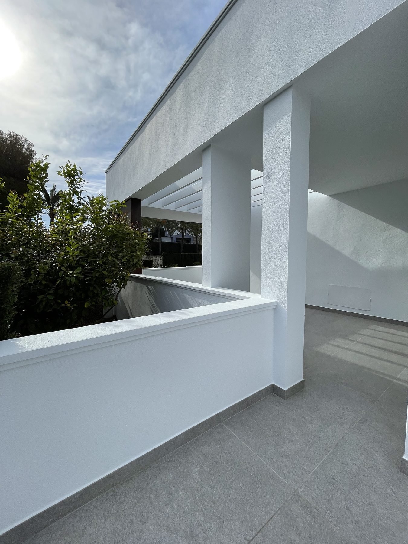 Pérgola y muro de terraza junto a la piscina recién pintados de blanco en villa de Moraira