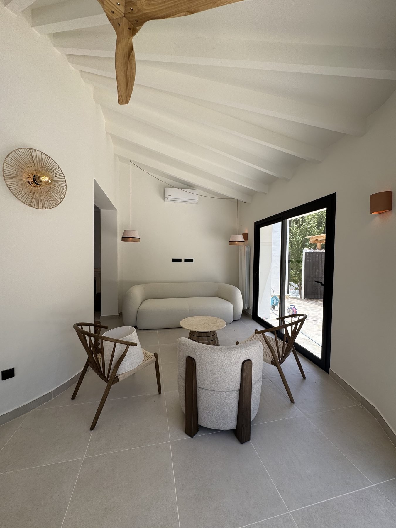 Salón con techo de vigas de madera recién pintado en Casa Gafarro, Jávea
